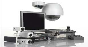 A security camera package is displayed, featuring a computer monitor, various cameras, a recording device, and a control panel. The entire setup is arranged against a plain white background.